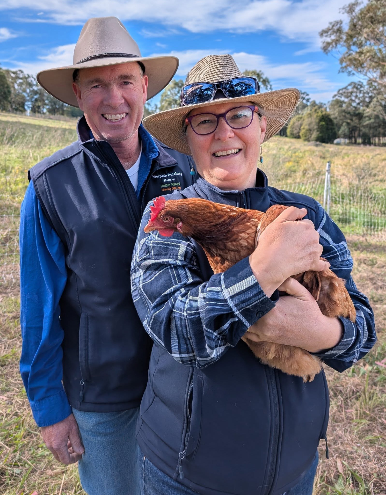 Pastured Eggs - Hunter Natural - Hunter Natural farmers holding one of their pastured hens on pasture